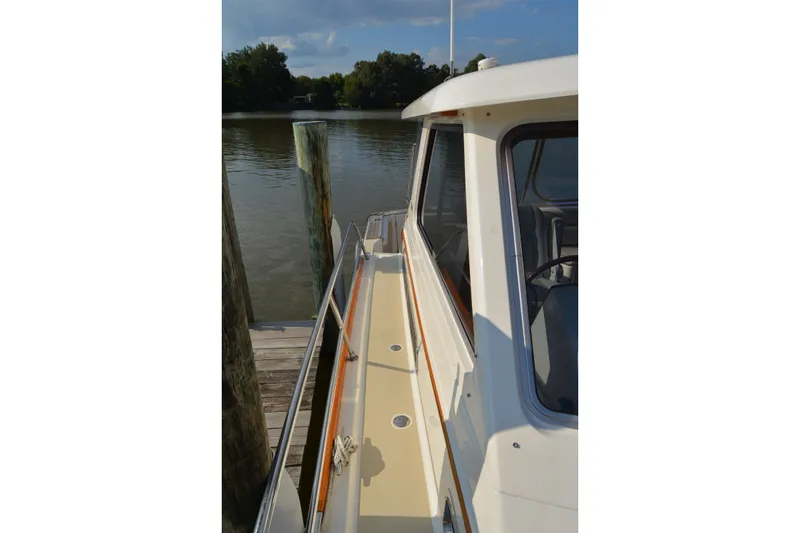 Slide: The Image of 2005 Sabre 38 Express yacht docked by a serene waterfront. - 14