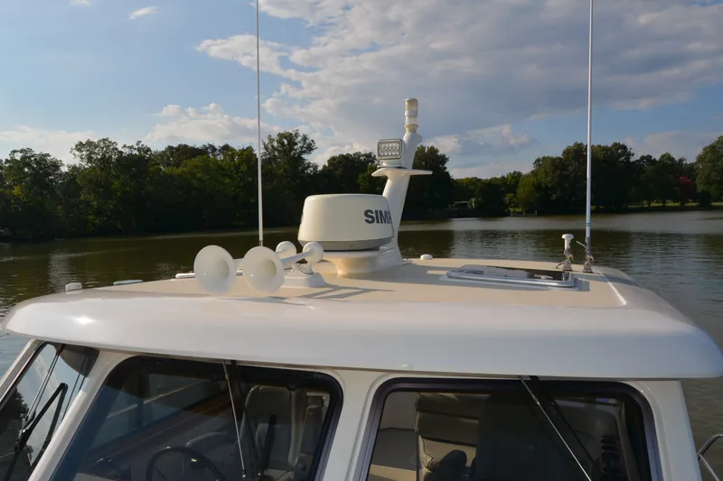 Slide: The Image of 2005 Sabre 38 Express boat with radar and antennas on a calm lake. - 12