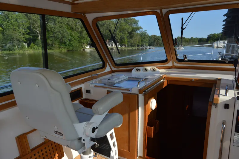 Slide: The Image of Interior view of 2005 Sabre 38 Express yacht helm with scenic river backdrop. - 36