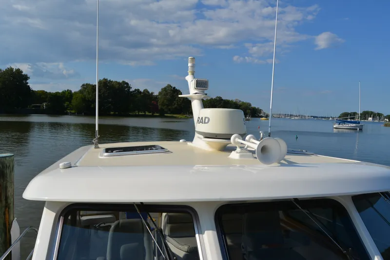 Slide: The Image of 2005 Sabre 38 Express yacht on calm water with radar and horn on deck. - 11