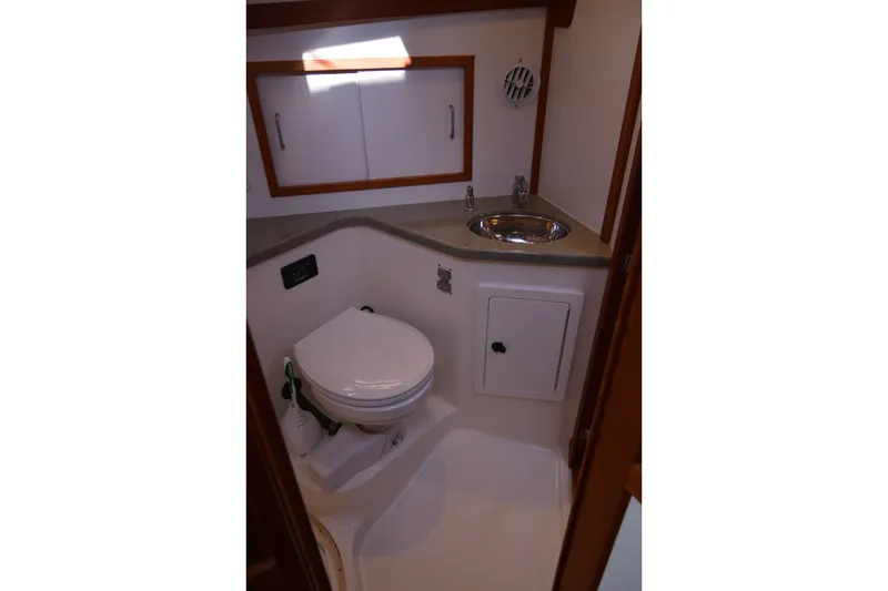 Slide: The Image of 2005 Sabre 38 Express yacht bathroom with toilet, sink, and storage cabinets. - 89