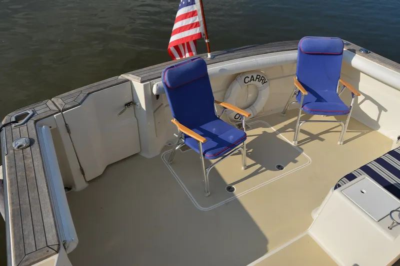 Slide: The Image of 2005 Sabre 38 Express boat deck with blue chairs and American flag. - 18