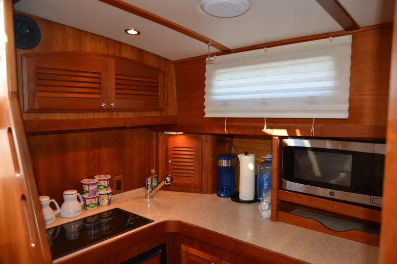 Slide: The Image of 2005 Sabre 38 Express yacht kitchen with wooden cabinetry, microwave, and countertop essentials. - 67
