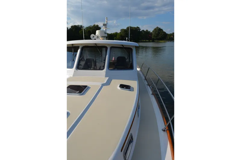 Slide: The Image of 2005 Sabre 38 Express boat on calm water, showcasing sleek design and spacious deck. - 17