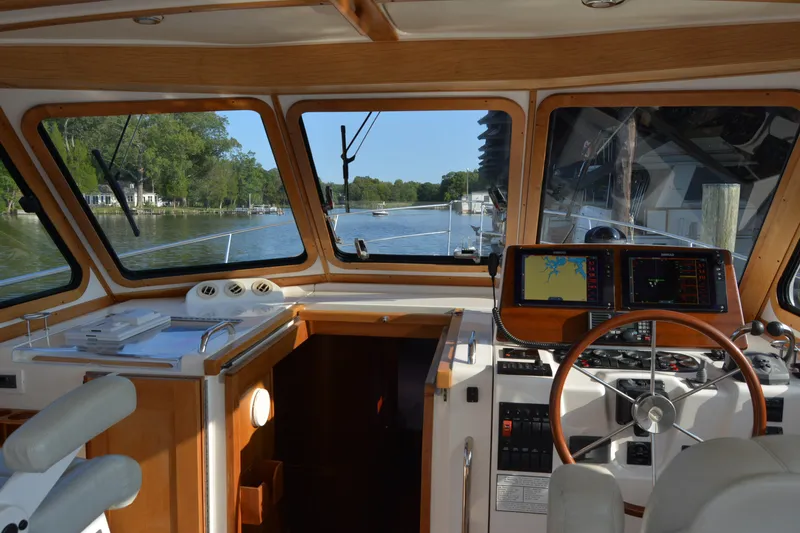 Slide: The Image of Interior view of 2005 Sabre 38 Express yacht cockpit with navigation equipment and scenic river backdrop. - 34