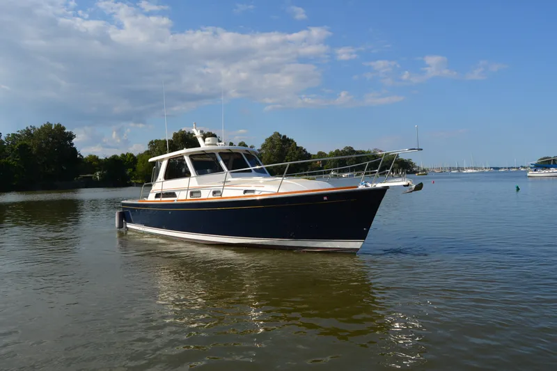 Slide: The Image of 2005 Sabre 38 Express boat on calm water under blue sky. - 5