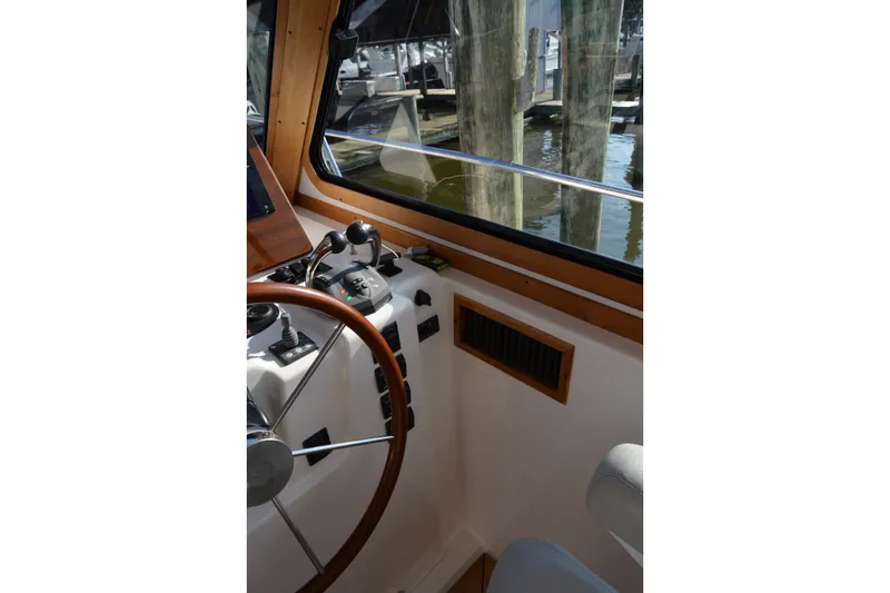 Slide: The Image of Interior helm of 2005 Sabre 38 Express boat with wooden steering wheel and controls. - 50