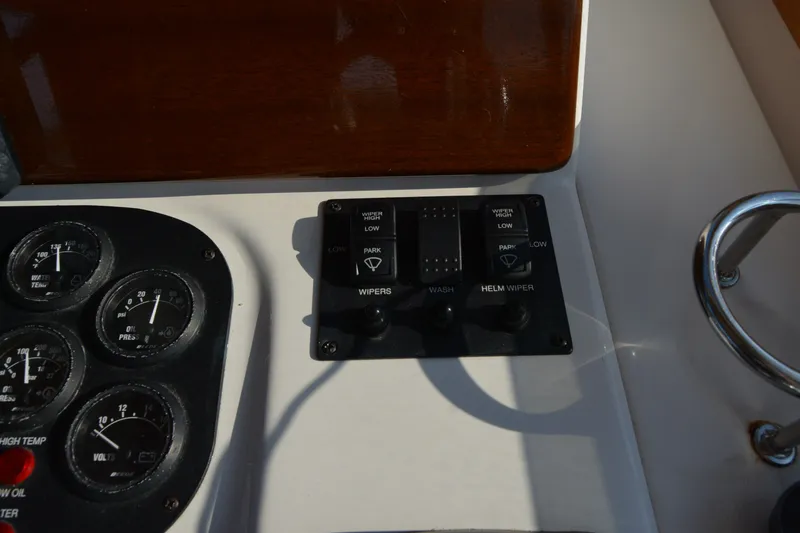 Slide: The Image of Dashboard controls of a 2005 Sabre 38 Express boat, featuring gauges and wiper switches. - 47