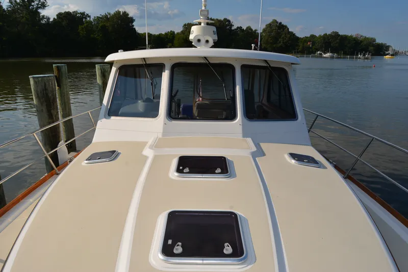 Slide: The Image of 2005 Sabre 38 Express yacht docked on a calm river with lush greenery. - 16