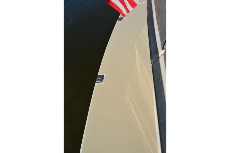 Slide: The Image of 2005 Sabre 38 Express boat deck with American flag, reflecting sunlight on water. - 30
