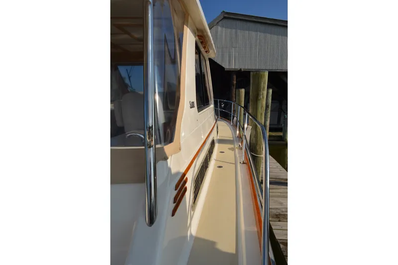 Slide: The Image of 2005 Sabre 38 Express yacht docked, showcasing sleek side deck and polished railings. - 22