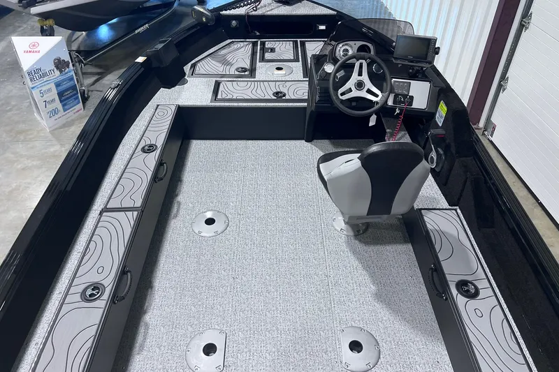 Slide: The Image of 2026 Smoker Craft Excursion 166 SC boat interior with steering console and storage compartments. - 7
