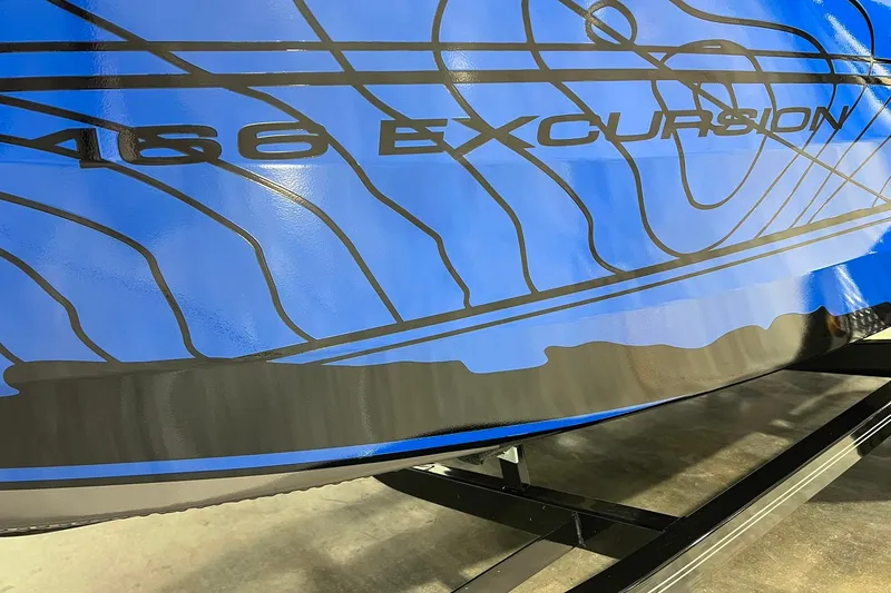 Slide: The Image of 2026 Smoker Craft Excursion 166 SC boat with blue and black design details. - 2