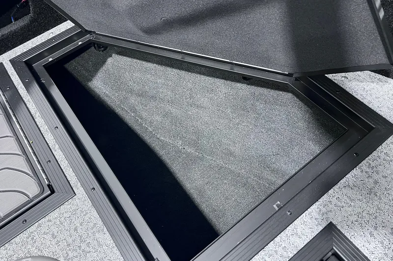 Slide: The Image of Open storage compartment in 2026 Smoker Craft Excursion 166 SC boat, featuring carpeted interior. - 18