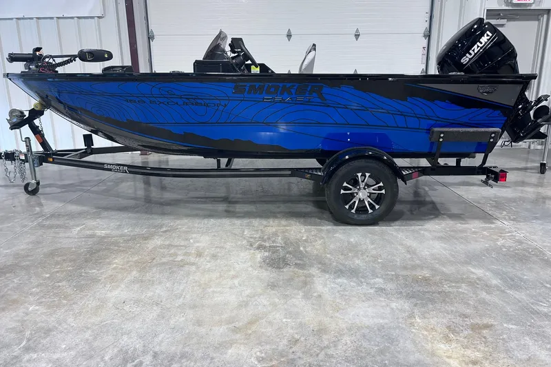 The Image of 2026 Smoker Craft Excursion 166 SC boat with Suzuki motor on trailer in garage. - 1