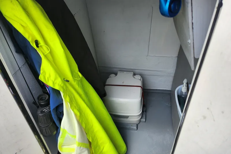 Slide: The Image of Interior of a 1999 World Cat 246 SF boat with rain gear and portable toilet. - 14