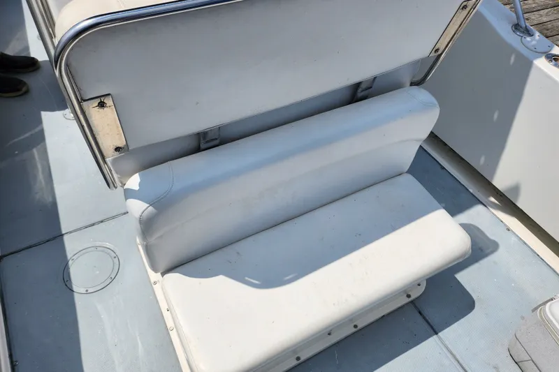 Slide: The Image of 1999 World Cat 246 SF boat seat, white upholstery, metal railings, and deck view. - 9
