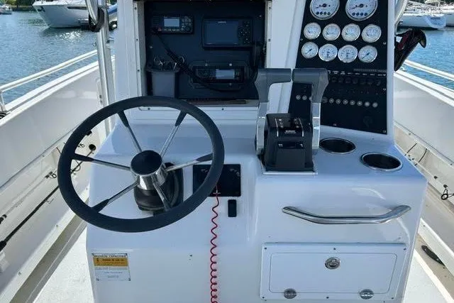 Slide: The Image of 1999 World Cat 246 SF boat helm with steering wheel, gauges, and controls. - 4