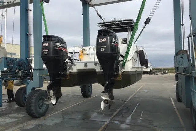 Slide: The Image of 1999 World Cat 246 SF boat with dual Suzuki 150 engines on a lift. - 3