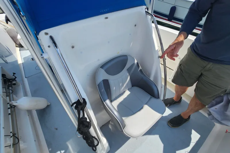 Slide: The Image of 1999 World Cat 246 SF boat interior with a gray seat and blue canopy. - 8