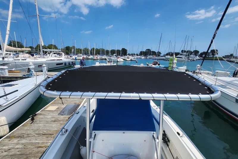 Slide: The Image of 1999 World Cat 246 SF boat docked in a marina, surrounded by sailboats. - 12