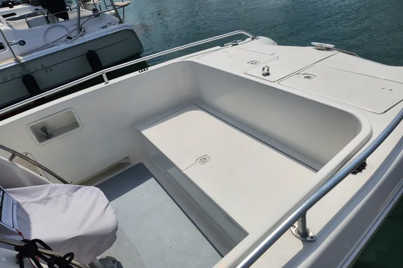 Slide: The Image of 1999 World Cat 246 SF boat interior with seating and railing, docked near water. - 6