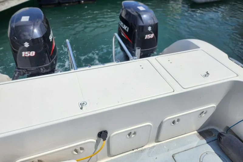 Slide: The Image of 1999 World Cat 246 SF boat with dual Suzuki 150 outboard motors on water. - 11