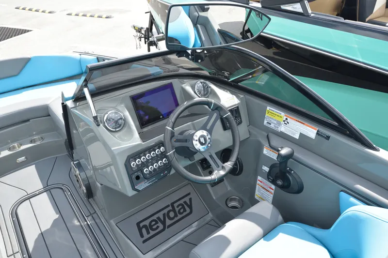 Slide: The Image of 2019 Heyday WT-2 boat dashboard with steering wheel, controls, and blue seating. - 18