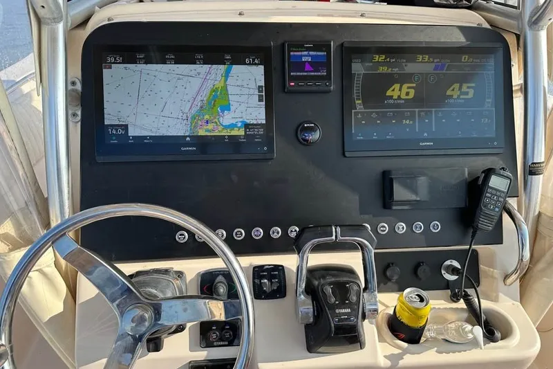 Slide: The Image of 2013 Grady-White Canyon 271 boat dashboard with navigation screens and controls. - 7