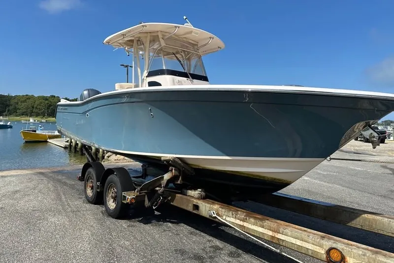 Slide: The Image of 2013 Grady-White Canyon 271 boat on trailer by the water, clear sky background. - 4