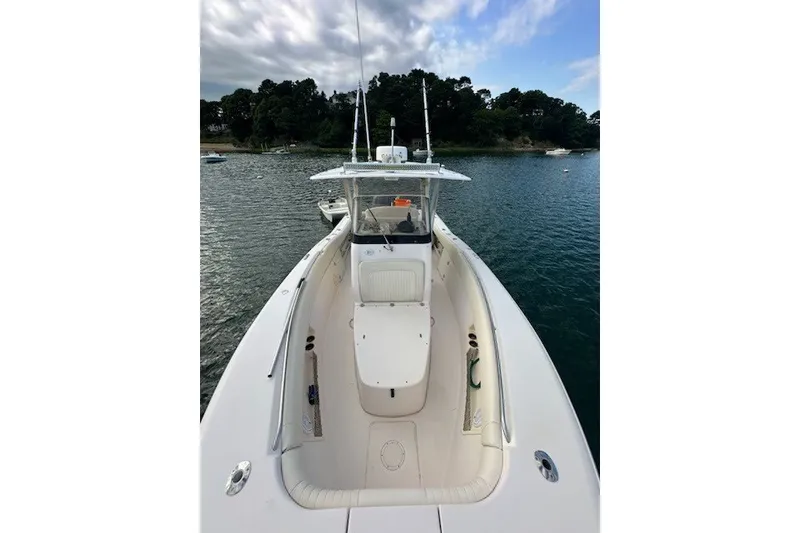 Slide: The Image of 2013 Grady-White Canyon 271 boat on calm water, featuring spacious deck and sleek design. - 5