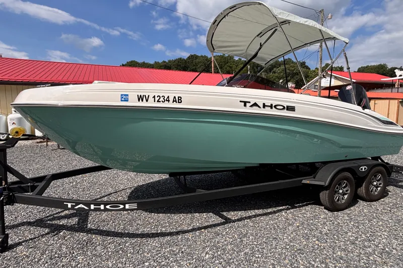 The Image of 2026 Tahoe T21 boat on trailer, green hull, parked outdoors under blue sky. - 0