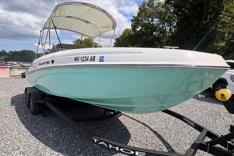 Slide: The Image of 2026 Tahoe T21 boat on trailer, parked outdoors under a clear sky. - 4