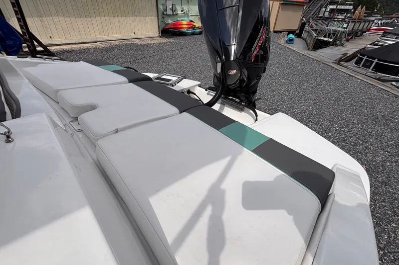 Slide: The Image of 2026 Tahoe T21 boat with cushioned seating and outboard motor at a marina. - 3