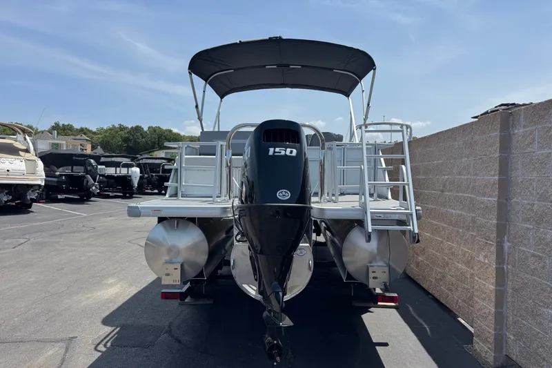 Slide: The Image of 2027 Godfrey Xperience 2286 Flip Lounge pontoon boat with 150 HP engine, parked outdoors. - 4