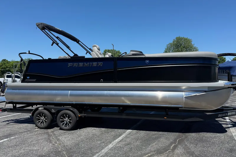 Slide: The Image of 2026 Premier 230 Sunsation RL pontoon boat on trailer, under clear blue sky. - 3