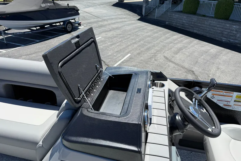 Slide: The Image of 2026 Premier 230 Sunsation RL boat interior with open storage compartment and steering wheel. - 19