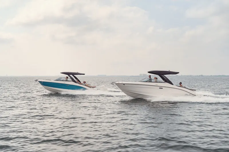 Slide: The Image of Two Sea Ray SLX 280 boats speed across the water under a cloudy sky. - 30