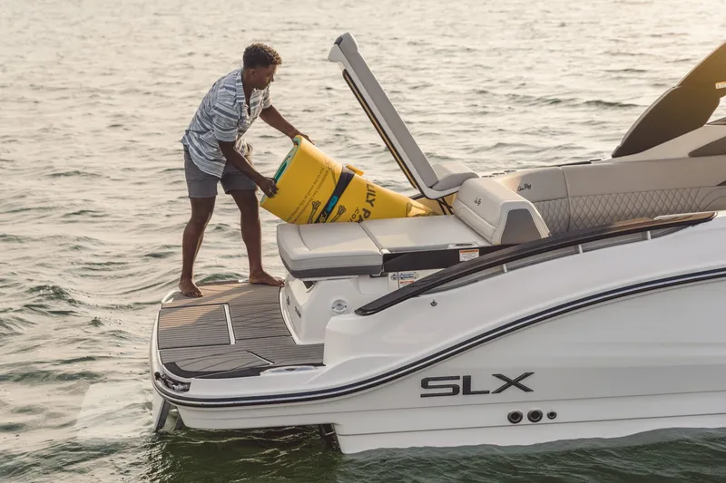 Slide: The Image of A man loads a yellow buoy onto a Sea Ray SLX 280 boat. - 46