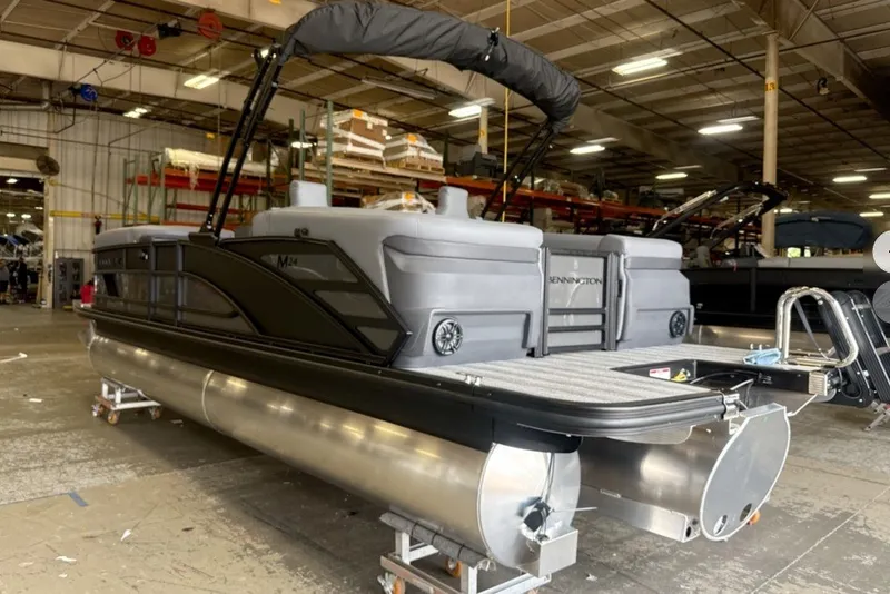 Slide: The Image of 2027 Bennington 24 M Open Fastback Quad Bench pontoon boat in a warehouse. - 5