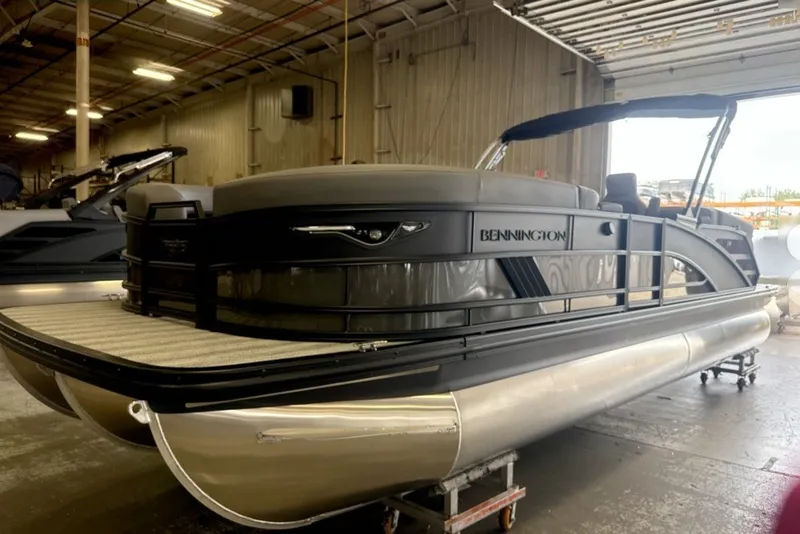 Slide: The Image of 2027 Bennington 24 M Open Fastback Quad Bench pontoon boat in warehouse setting. - 3