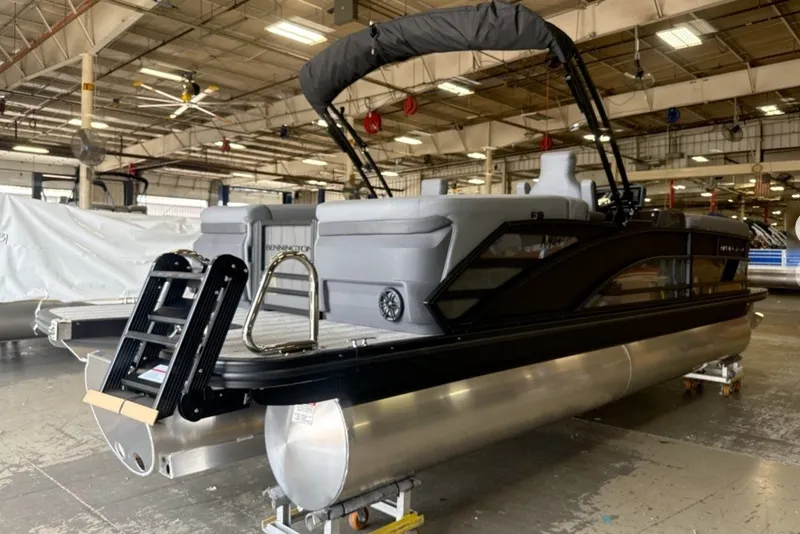 Slide: The Image of 2027 Bennington 24 M Open Fastback Quad Bench pontoon boat in a warehouse setting. - 6