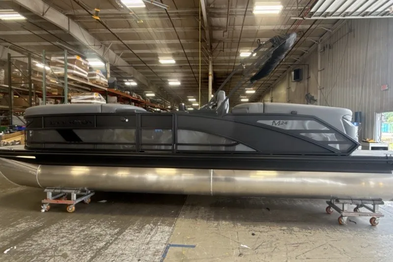 Slide: The Image of 2027 Bennington 24 M Open Fastback Quad Bench pontoon boat in warehouse setting. - 4