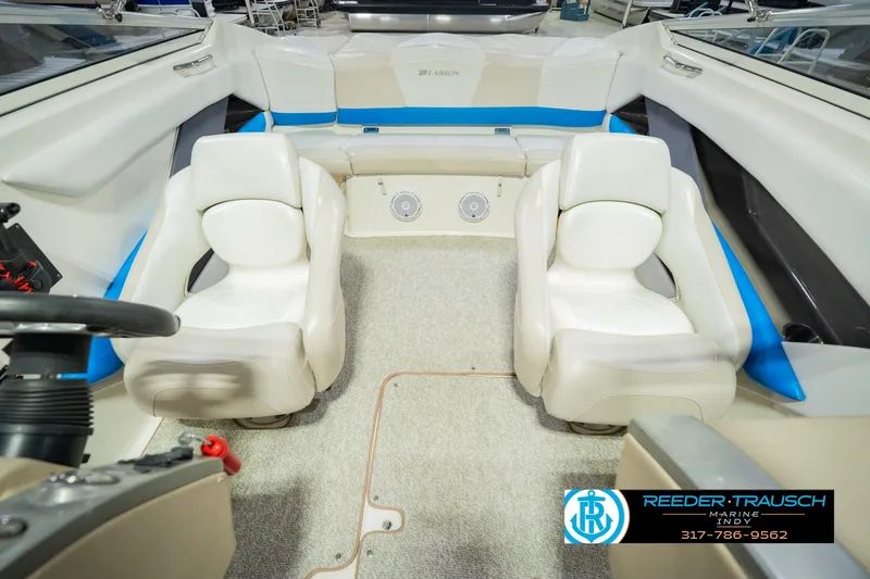 Slide: The Image of Interior of 2007 Larson LXi 228 Wakeboard Edition boat with white seating and steering wheel. - 24