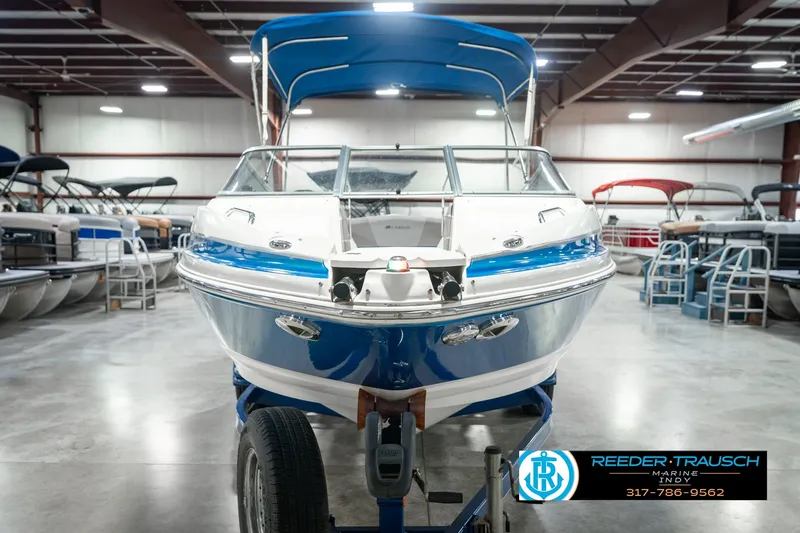 Slide: The Image of 2007 Larson LXi 228 Wakeboard Edition boat in showroom with blue canopy. - 4