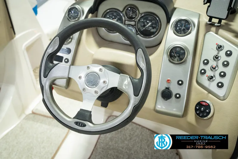 Slide: The Image of 2007 Larson LXi 228 Wakeboard Edition dashboard with steering wheel and control panel. - 32