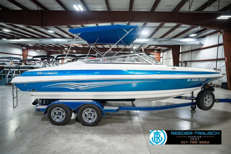 Slide: The Image of 2007 Larson LXi 228 Wakeboard Edition boat in showroom, blue and white design. - 6