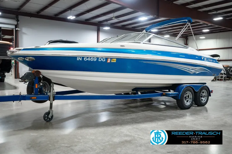 Slide: The Image of 2007 Larson LXi 228 Wakeboard Edition boat on trailer in indoor showroom. - 1