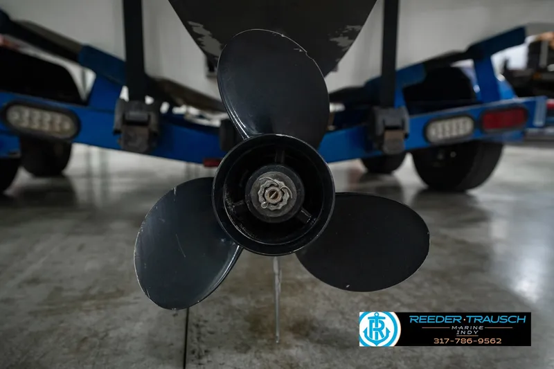 Slide: The Image of 2007 Larson LXi 228 Wakeboard Edition boat propeller and trailer in a garage. - 55