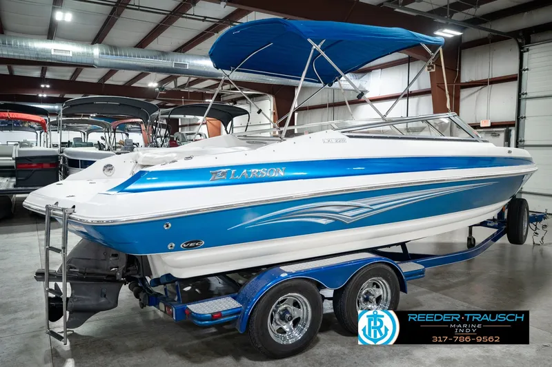 Slide: The Image of 2007 Larson LXi 228 Wakeboard Edition boat with blue and white design in indoor showroom. - 8